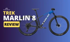 A blue and black "Trek Marlin 8" mountain bike is angled right against a blue background with "REVIEW" in yellow.